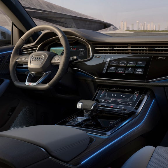 Internal view of drivers control area with city skyline seen through the front window.