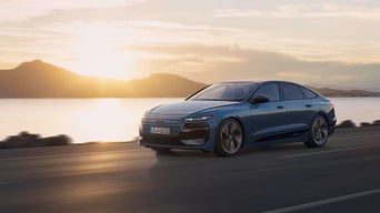 Ein Audi fährt in den Sonnenuntergang