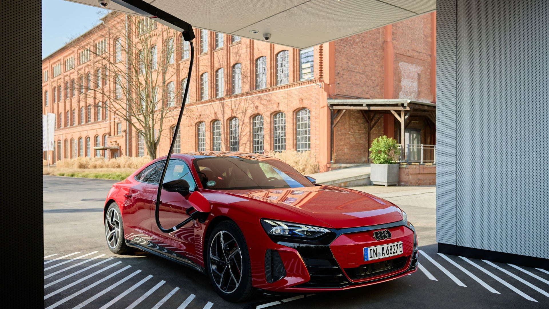 Audi Q6 SUV e-tron quattro in rot steht im Audi Charging Hub und lädt