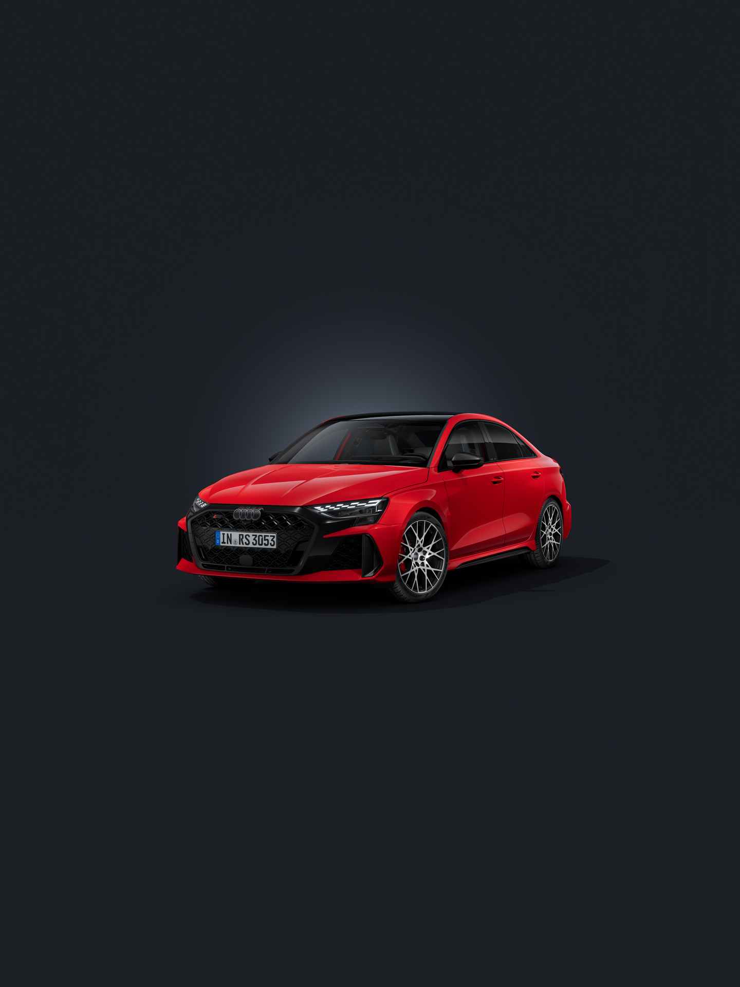 Die Audi RS 3 Limousine schräg von vorn auf dunklem Hintergrund.