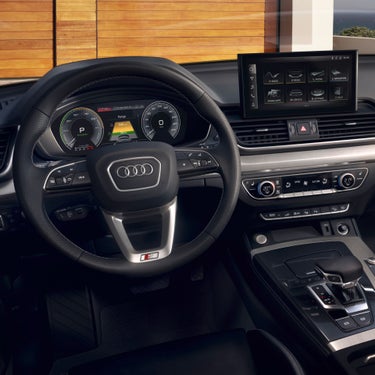 Interior view of a car featuring a steering wheel with logo, digital dashboard, and touchscreen panel.