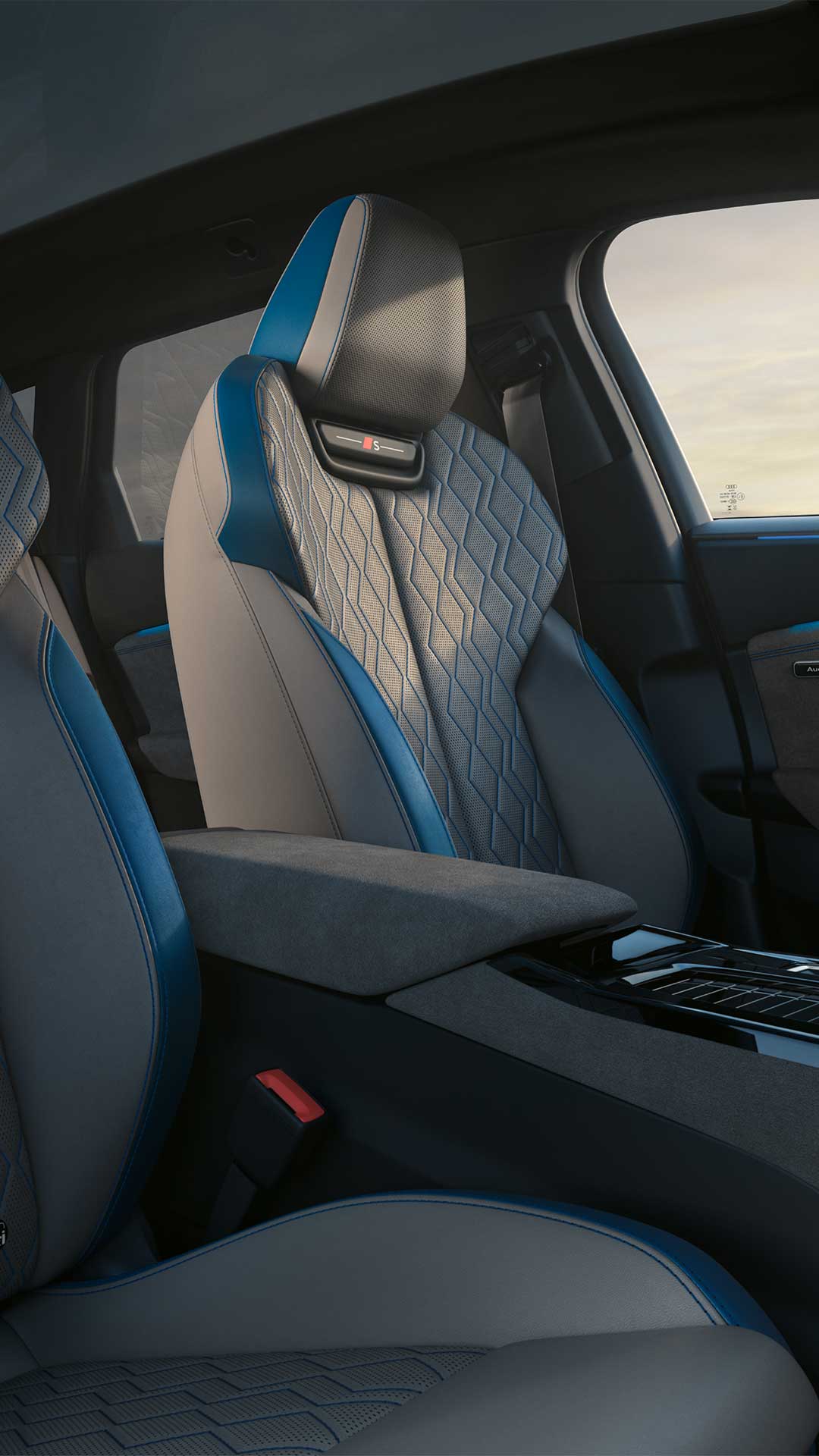 Vordersitze eines Audi S6 Avant e-tron in grau mit blauer Rautensteppung und „S“-Logo, Aufnahme bei Tageslicht von der Beifahrerseite.
