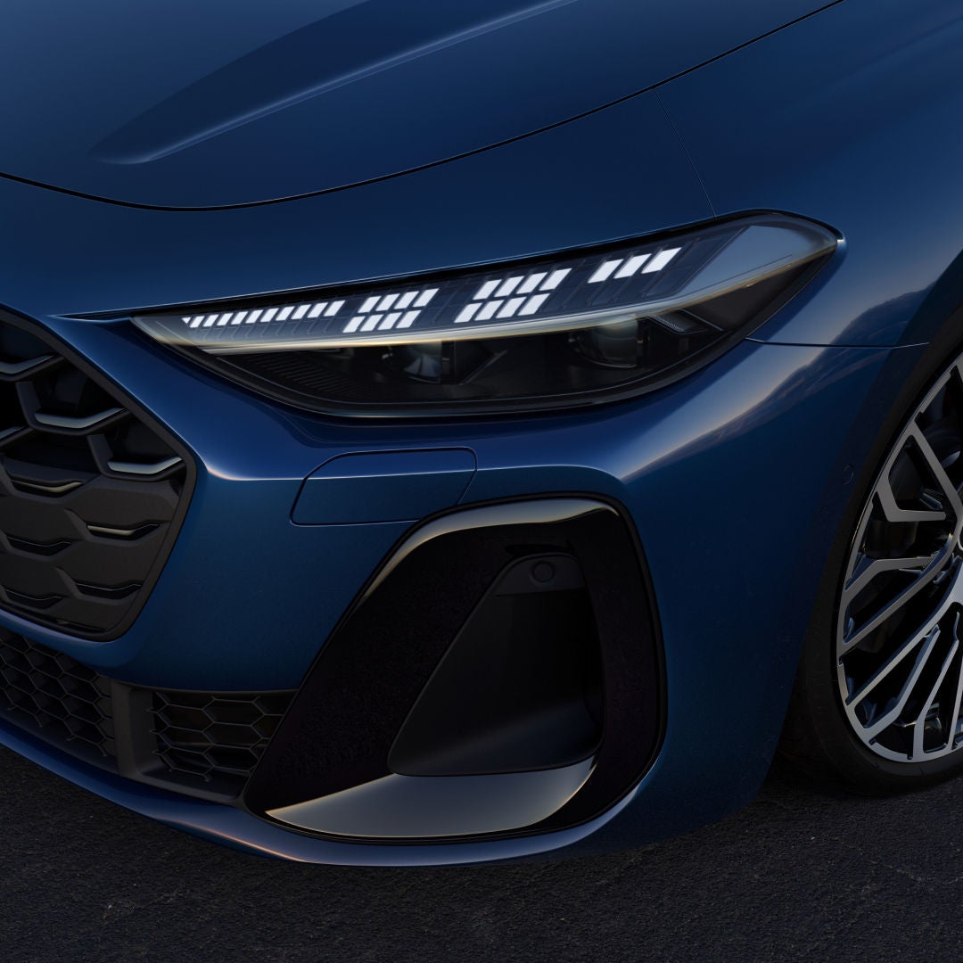 A close up of the front left light of a blue Audi car