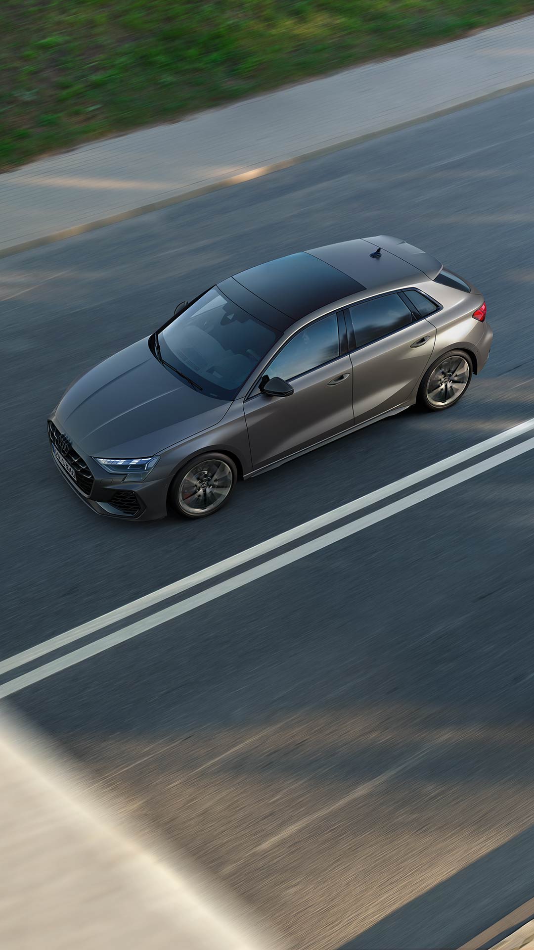 Silberner Audi S3 Sportback vor modernem Gebäude bei Tageslicht seitlich fotografiert.