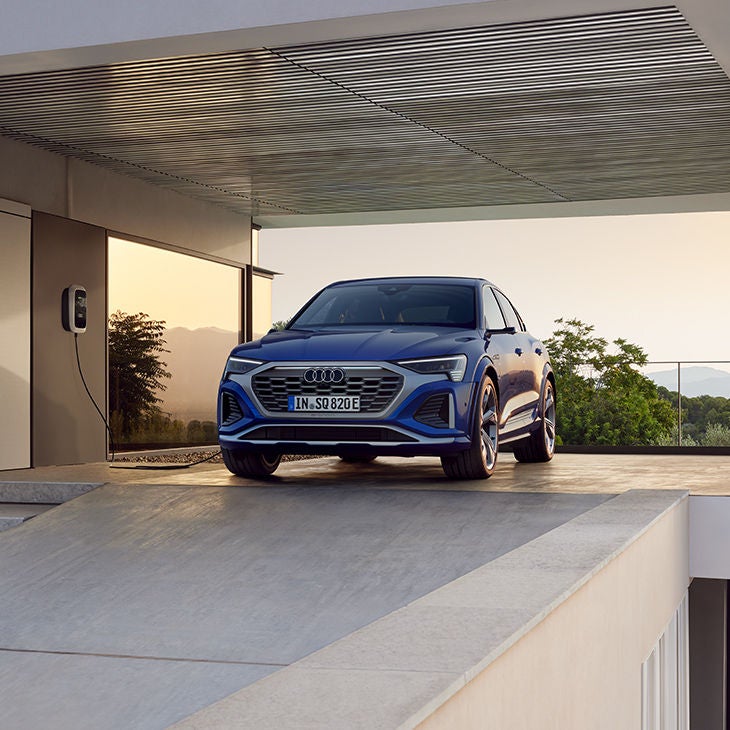 Foto de un coche SUV eléctrico de Audi y las soluciones de carga eléctrica disponibles.