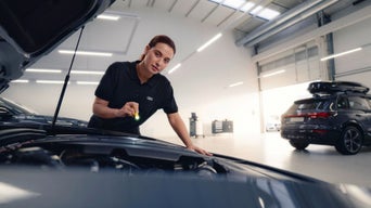 A man repairing a car with tools in hand