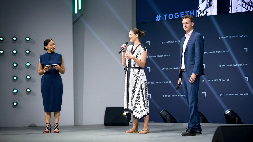 Judith Kühn-Gerres (Mitte), Moderatorin Jennifer Sarah Boone (links) und Dale Rickert, Head of Conference GREENTECH FESTIVAL (rechts) stehen auf einer Bühne.