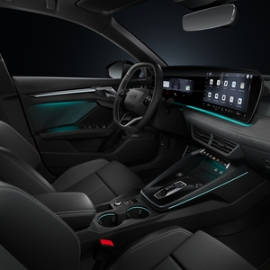 Blick von der Beifahrerseite auf das Cockpit mit Lenkrad, Mittelkonsole, digitale Displays und das Ambiente-Licht.