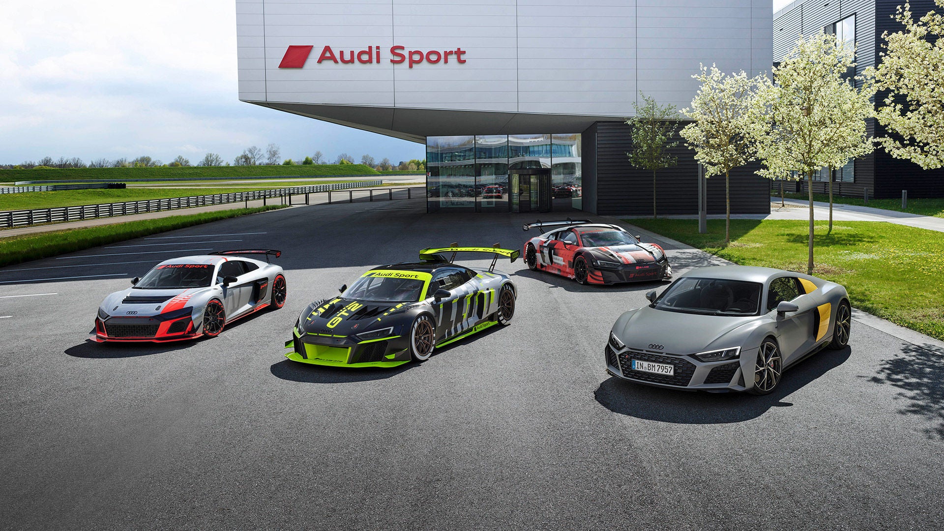 Alla Audi Customer Racing-modeller parkerade framför ett garage. Fotade något ovanifrån.