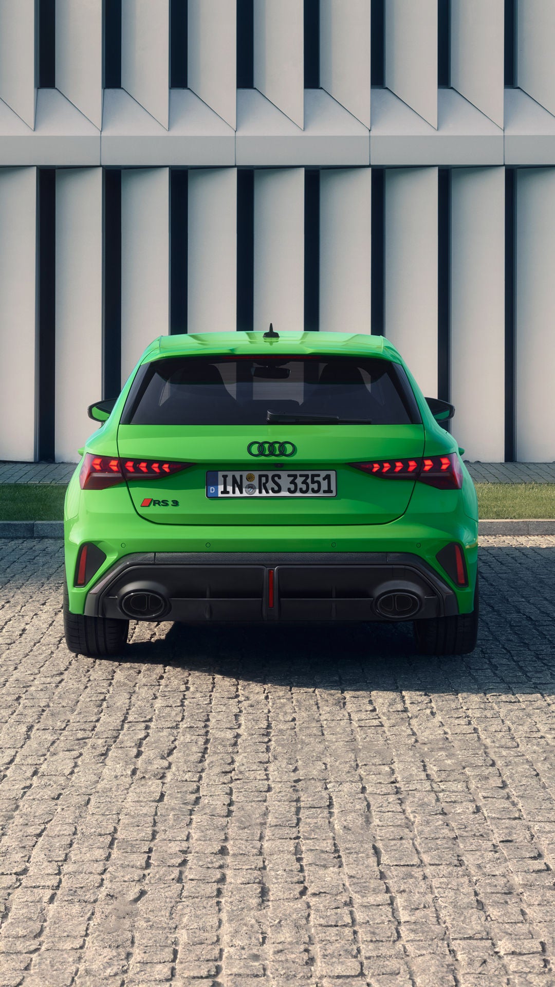 Der RS 3 Sportback von schräg hinten fährt auf einer Brücke, im Hintergrund eine Skyline.