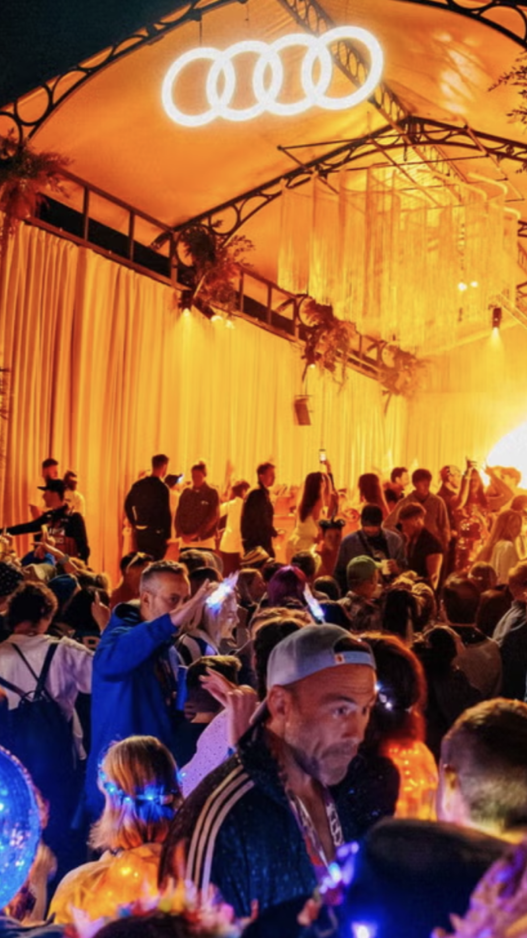 A grey sports car parked outdoor with modern architecture and skyline in the background