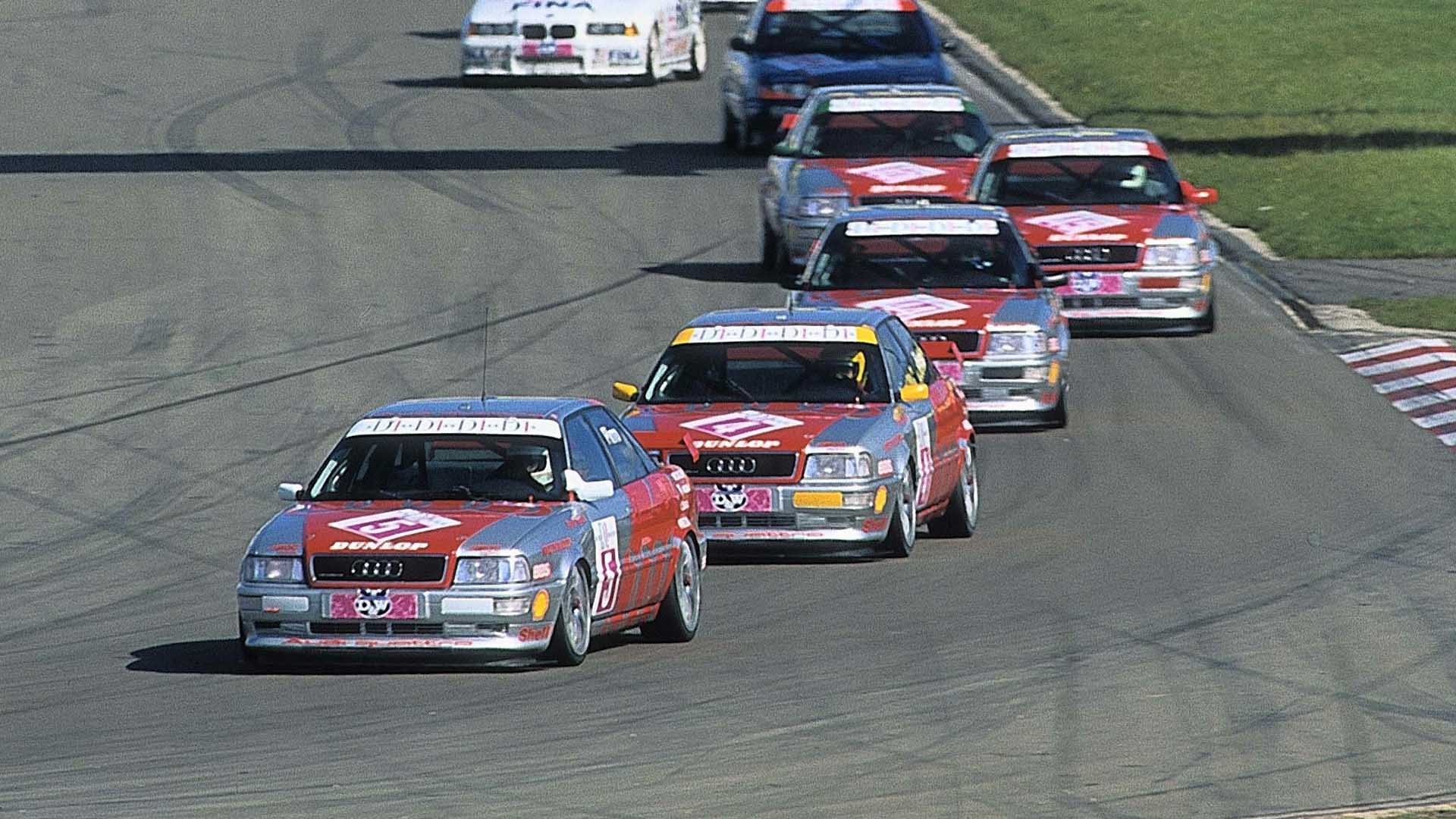 Das Foto zeigt fünf Audi 80 Competition-Rennwagen, die ein Rennen auf dem Nürburgring im Jahr 1994 anführen.