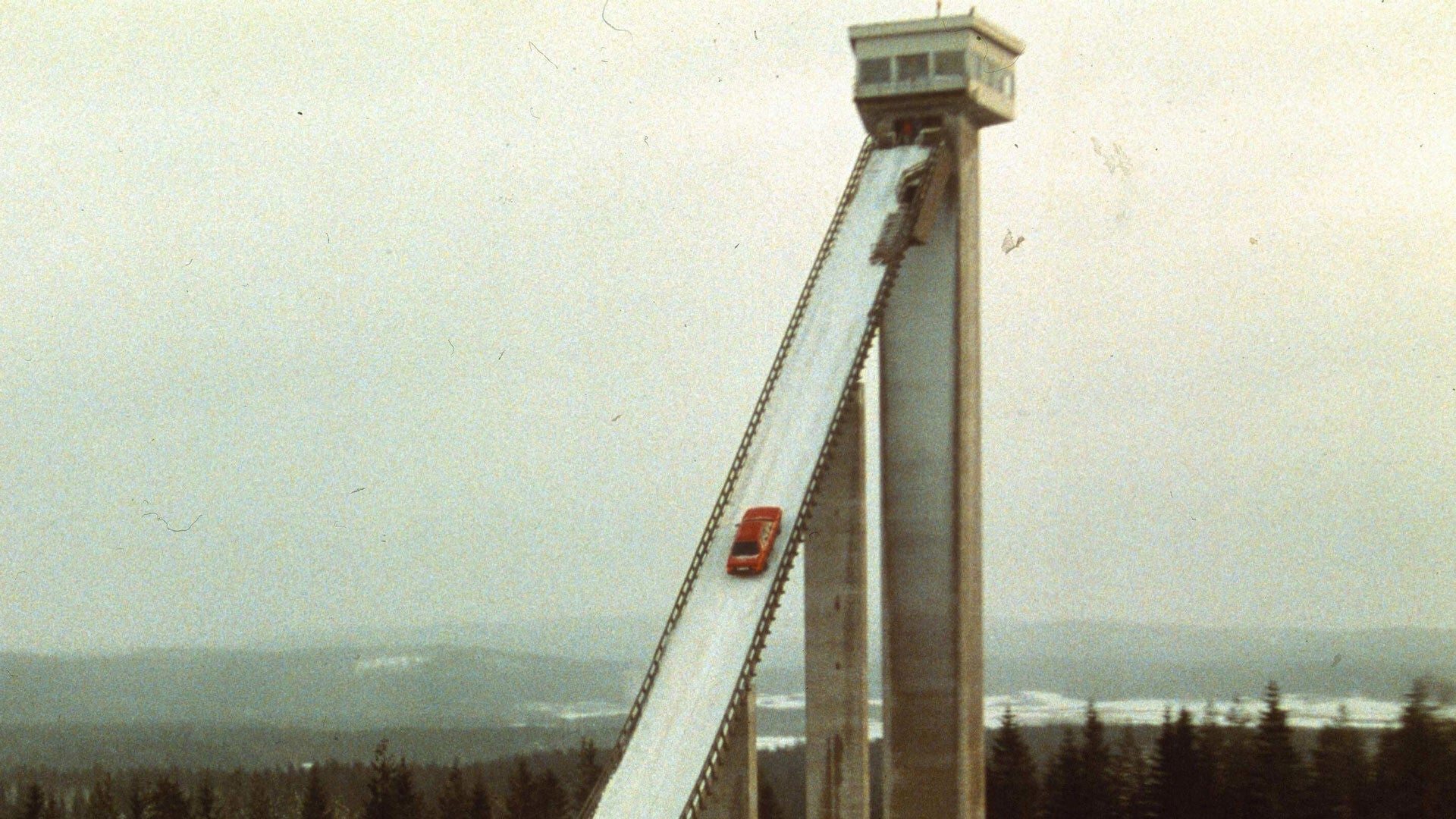 A red Audi drives up a ski jump