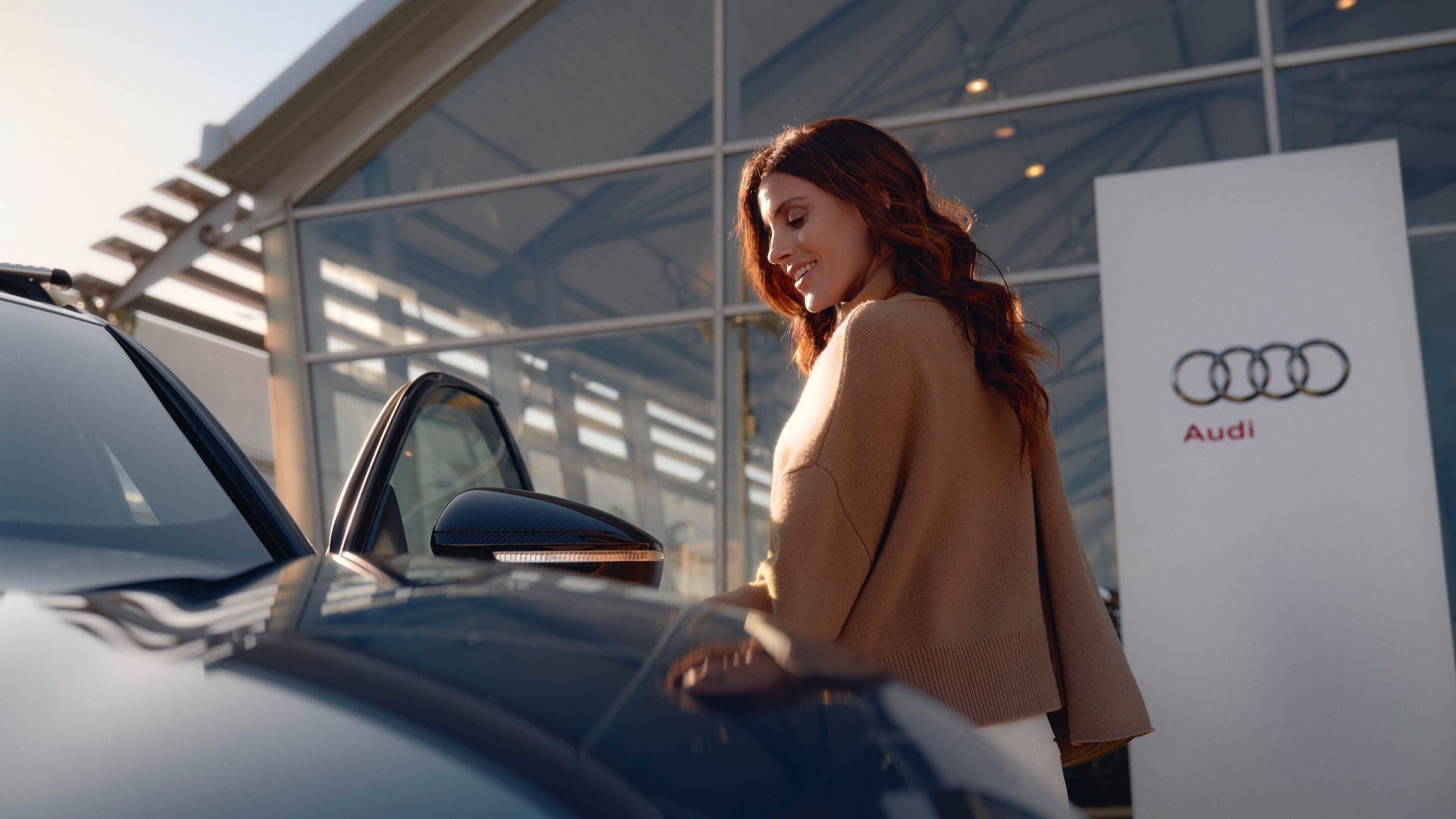 un uomo a finaco alla propria Audi parcheggiata