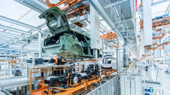 Assembly line in a car factory with car bodies in production.