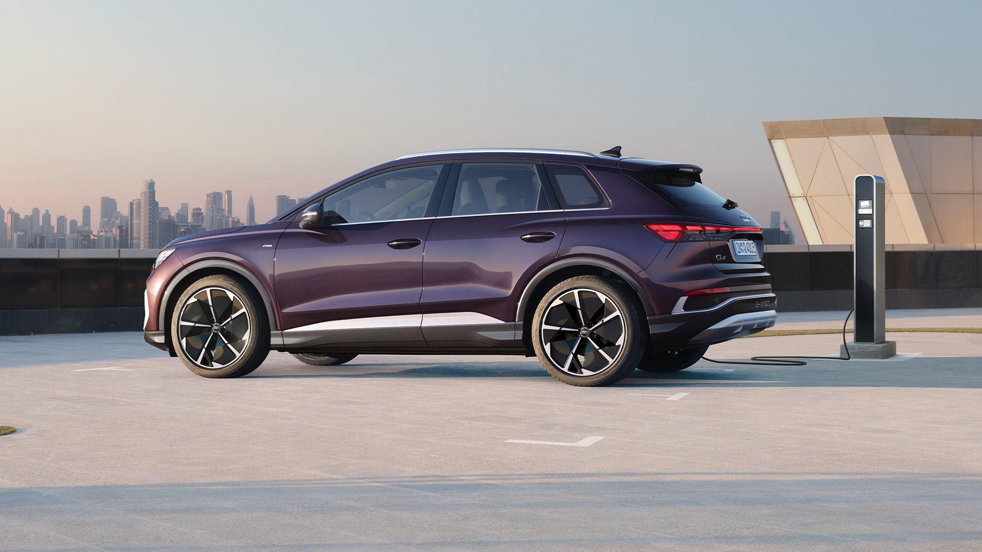 Lilaner Audi Q4 e-tron wird an Ladesäule geladen