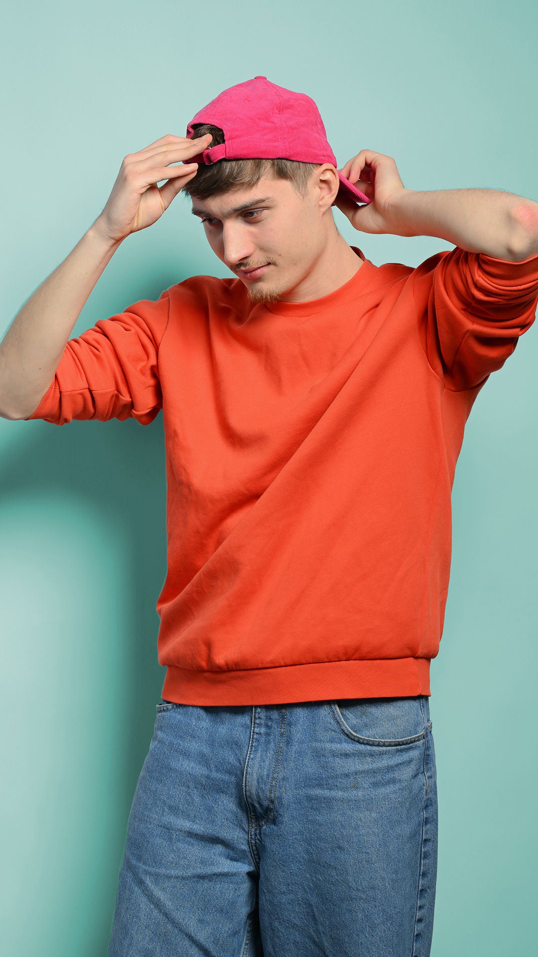 Noah schaut nach unten und richtet seine Cap, die er auf dem Kopf trägt 