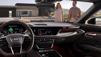 En kvinne og en mann går mot en Audi, det indre av kjøretøyet kan sees i forgrunnen.