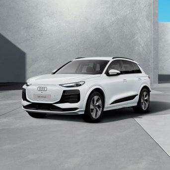 Ein weißes, modernes SUV steht schräg von vorn fotografiert vor einem schlichten, grauen Hintergru