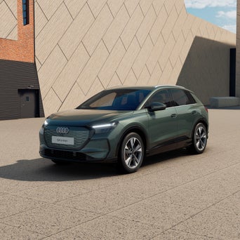 Ein graublauer Audi A3 Sportback von schräg vorne fotografiert vor einer modernen Kulisse.