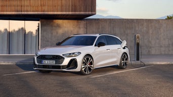 Weißer Audi A5 an einer Ladestation vor einem Gebäude