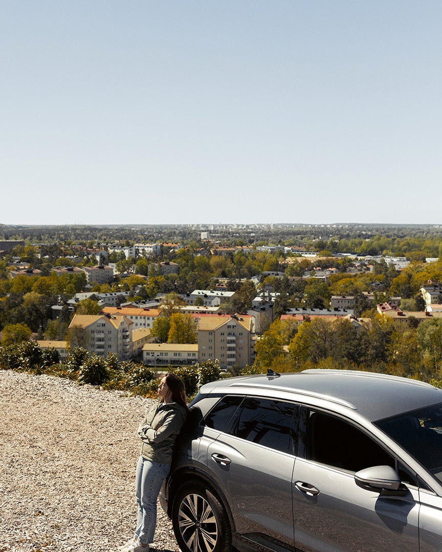 Fanny lutar mot en Audi, utsikt från Hammarbybacken i bakgrunden.