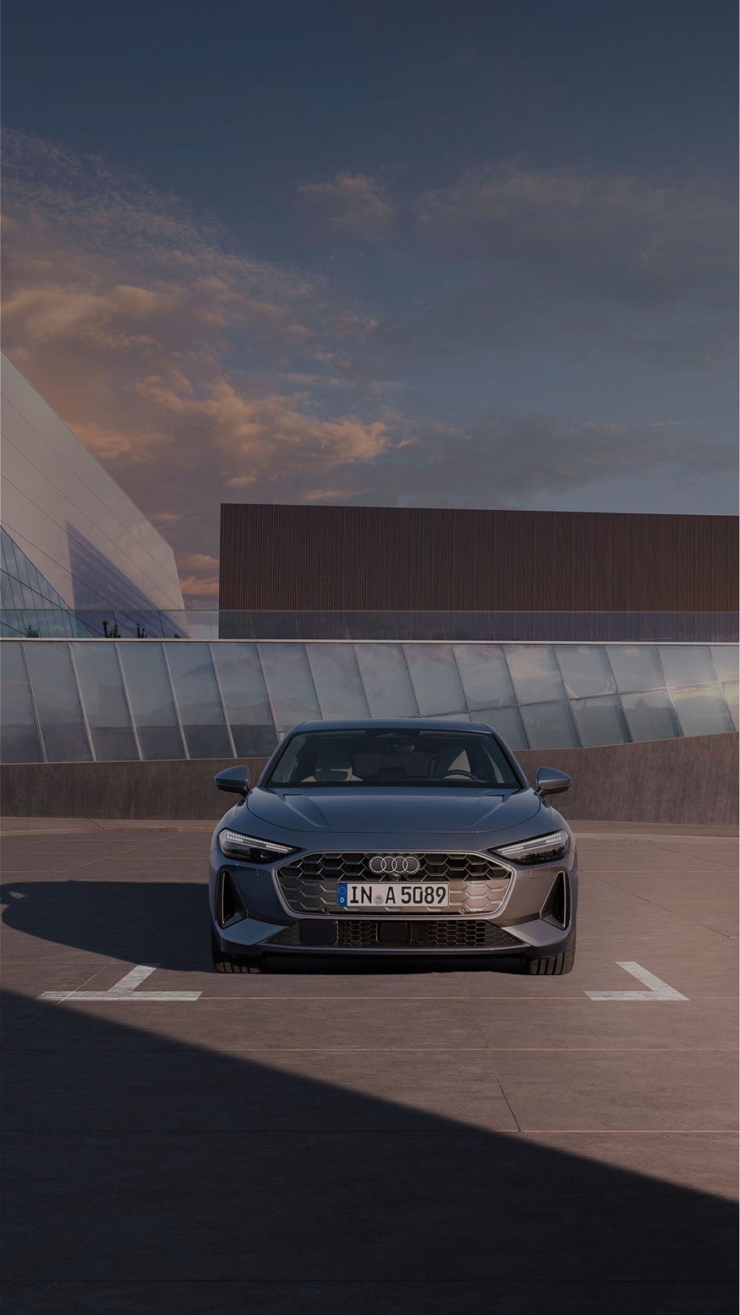 An Audi e-tron GT parked in front of modern building