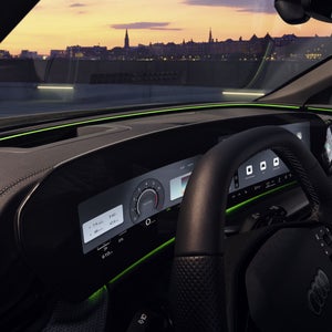 Vue à travers la vitre conducteur vers le poste de conduite de l’Audi Q5 SUV. L’accent est mis sur l’éclairage d’interaction vert au bas du pare-brise.