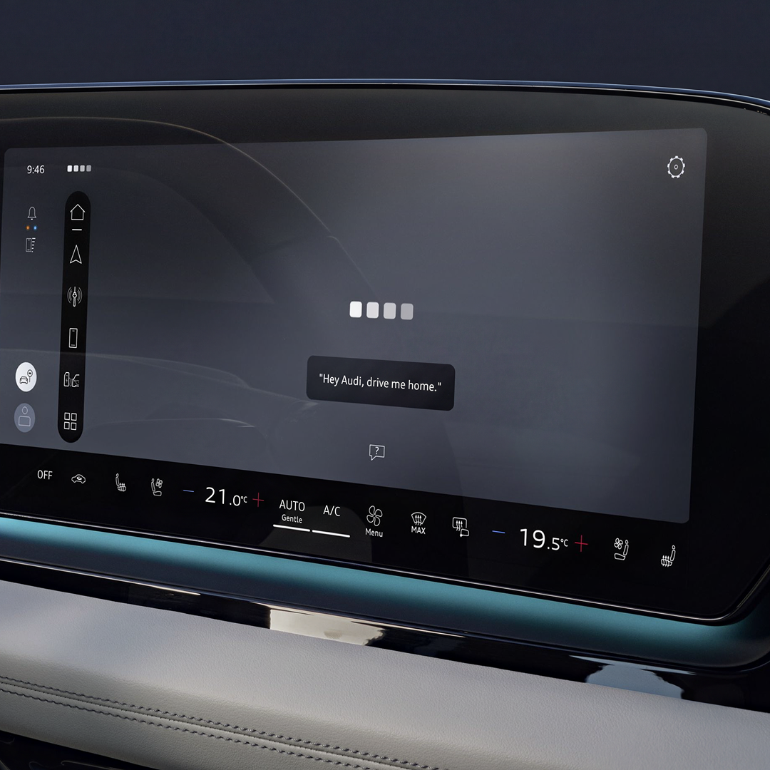 Close-up of the MMI touch display showing the Audi assistant interface.
