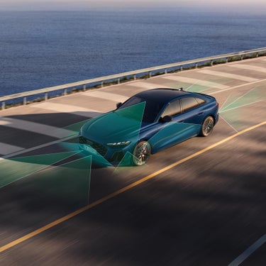 Blaue Audi A5 Limousine auf Straße, grüne Flächen zeigen die aktiven Sensorbereiche der Assistenzsysteme.
