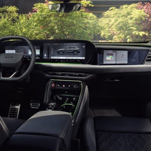 Vy från baksätet till förarhytten på Q5 SUV. Fokus ligger på panoramaskärmen med Audi Virtual Cockpit och MMI-displayen.