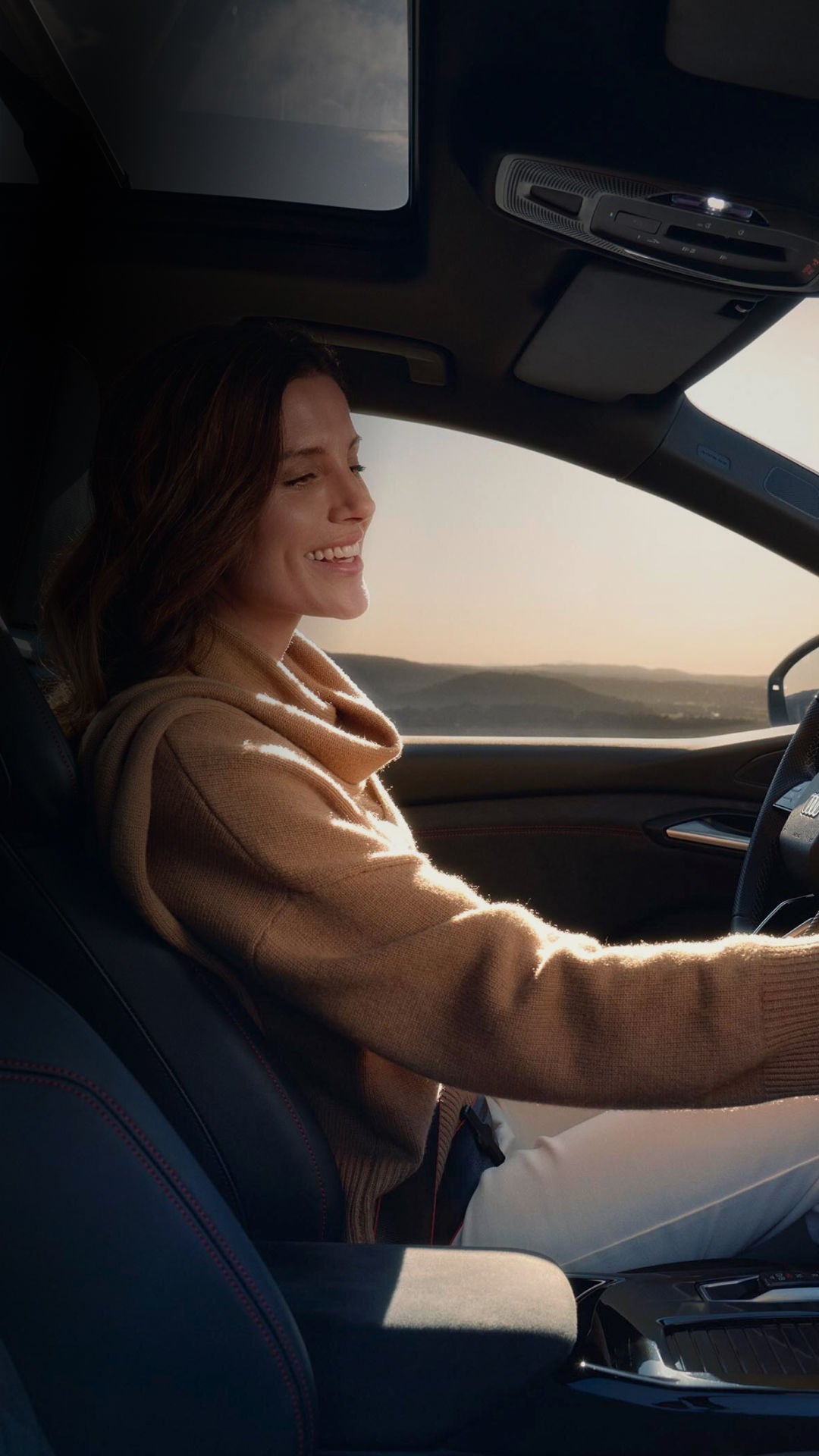 A woman in the driver's seat of an Audi car selecting a setting from the digital dashboard