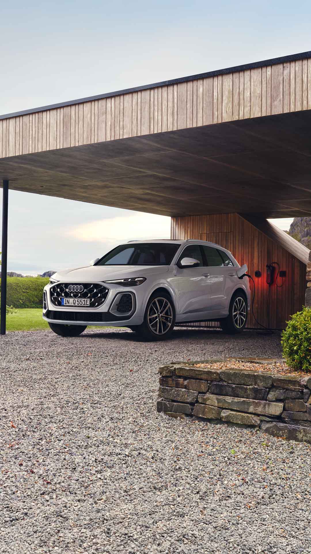 Een Audi Q5 onder de carport van een modern huis