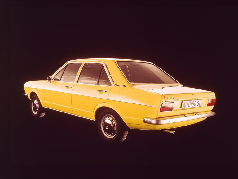 Heck-Seitenansicht eines Audi 80 GL in Gelb auf einem dunklen Hintergrund