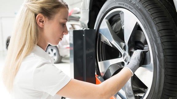 Drei Männer schauen unter die Motorhaube eines Audi e-tron.