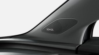 Car interior with a detailed view of a Sonos speaker on the door panel.