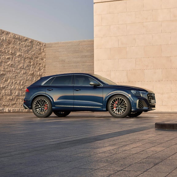Parked Audi SQ8 along a styled brick wall.