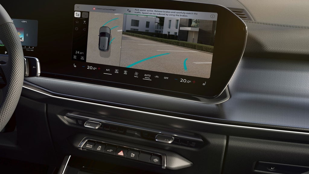 An Audi vehicle in a showroom with brand projection on wall