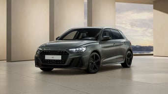 Une Audi A1 grise est exposée dans une sorte de salle d'exposition.