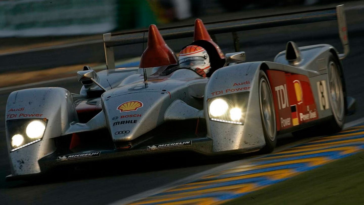Audi R 15 sedd lite snett framifrån körandes på bana.