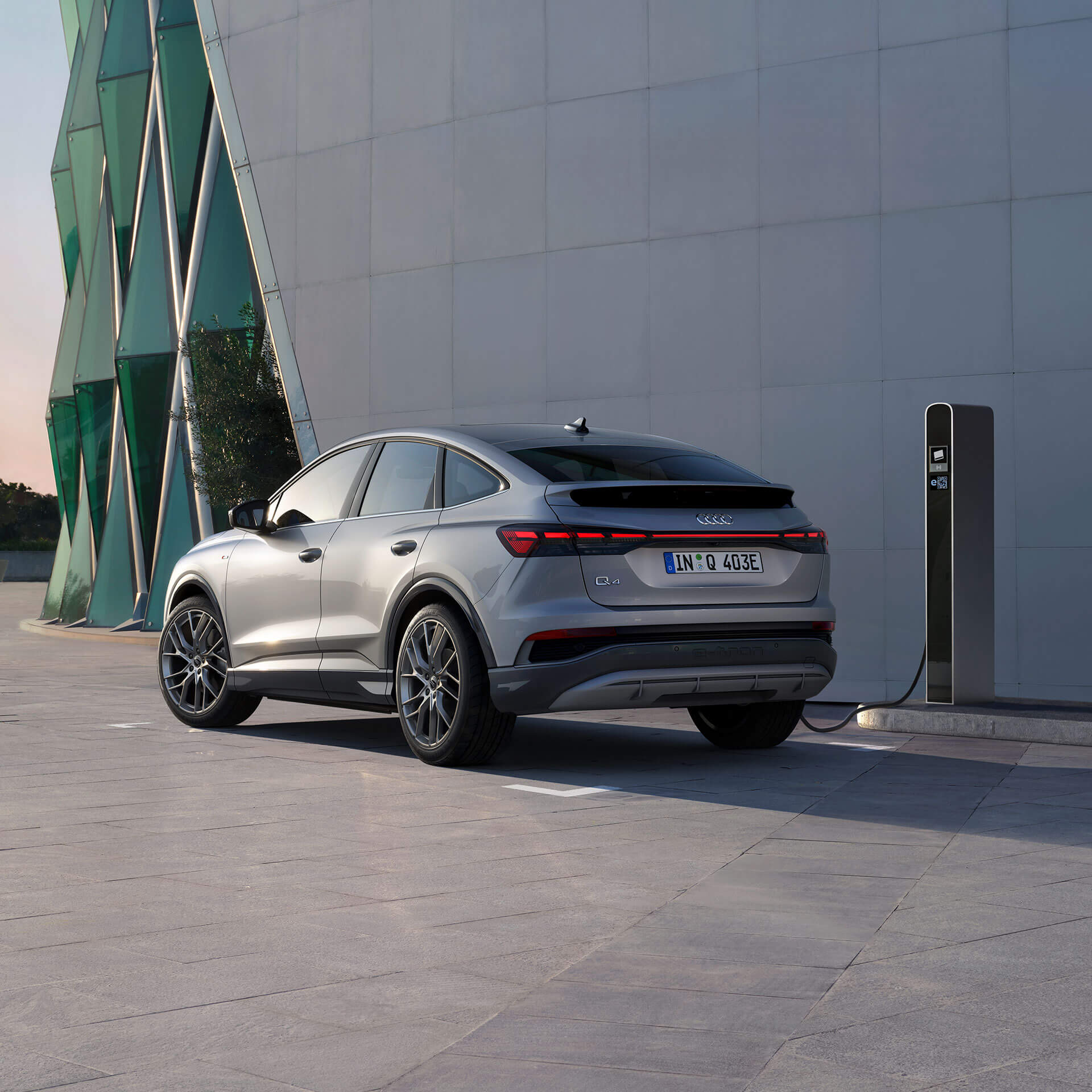 Q4 e-tron står parkerad längs en byggnad.