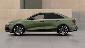 Green Audi new S3 Saloon parked near a beige wall
