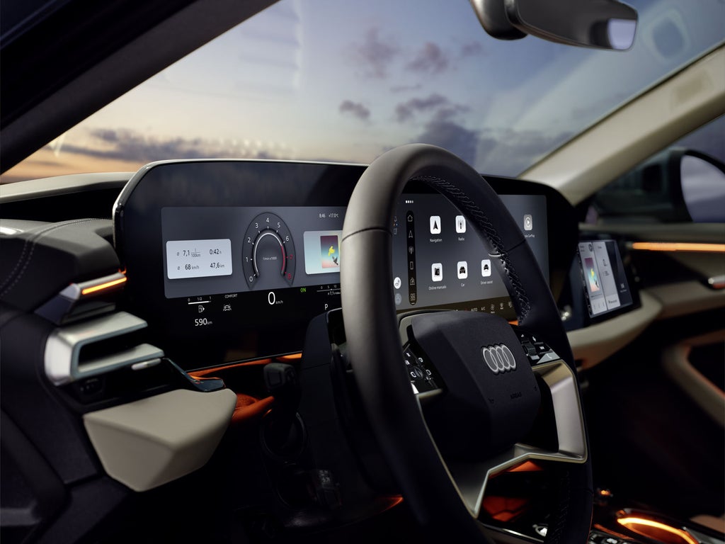 Close-up of the steering wheel and driver displays, viewed from the driver's side window.