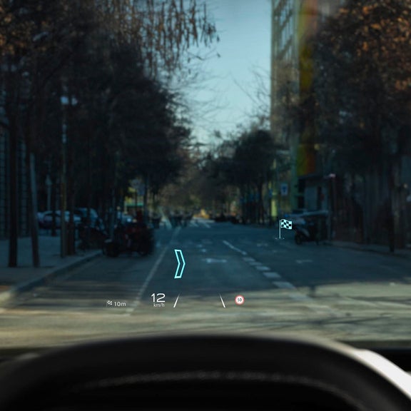 Audi Q3 head-up display showing speed, navigation, and distance info projected onto the windshield of city street view.