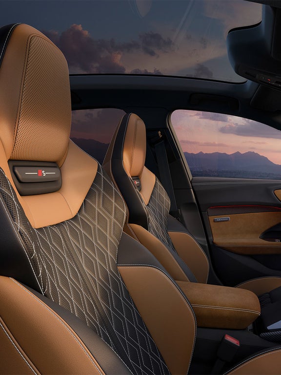 Innenraum der Audi S5 Limousine mit Sportsitzen in Schwarz-Braun und digitalem Cockpit bei Sonnenuntergang.