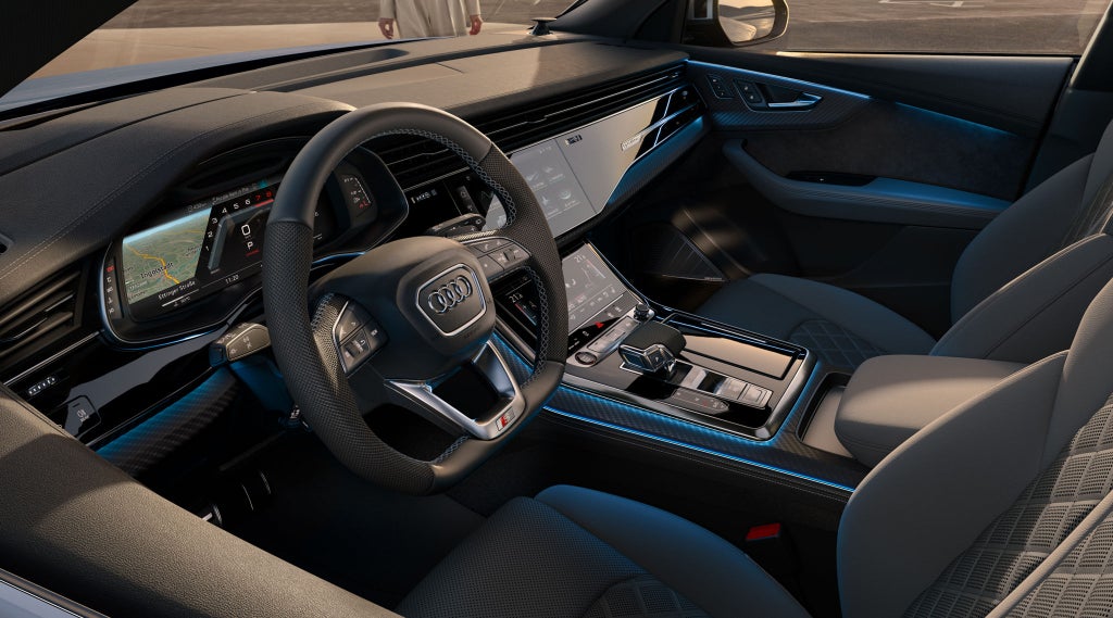 Kijkje in de cockpit van de SQ8 SUV vanaf de bestuurderszijde, met de nadruk op het stuur, de digitale displays en de sportstoelen.