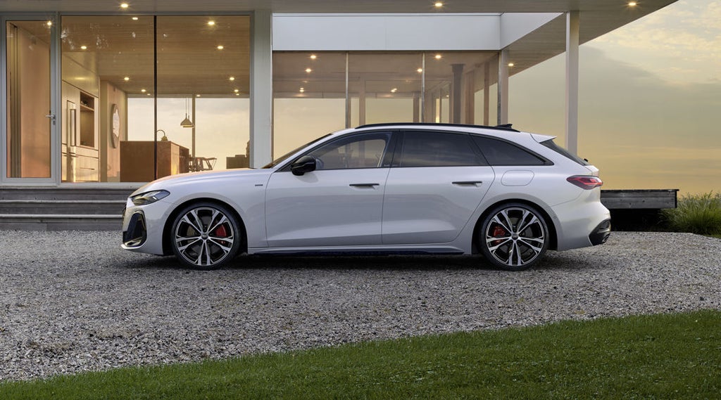 A5 Avant e-hybrid i sidoprofilen framför ett modernt bostadshus.