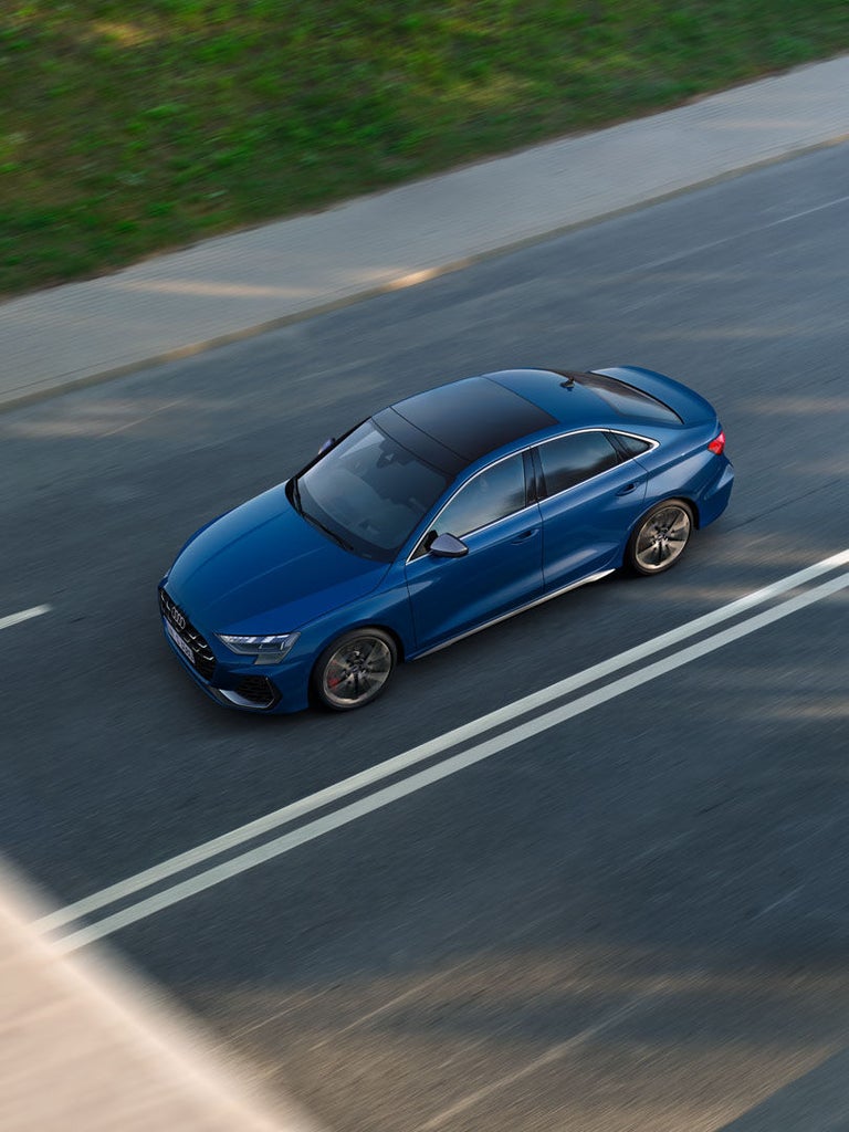 Blaue Audi S3 Limousine aus der Vogelperspektive beim Fahren auf zweispuriger Straße.