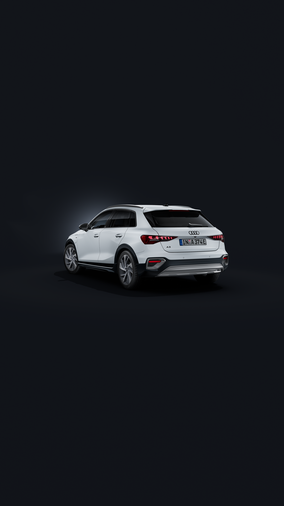 Der Audi A3 allstreet e-hybrid schräg von hinten auf dunklem Hintergrund.