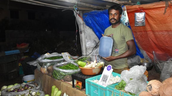 Man behind a market vegetable stall.